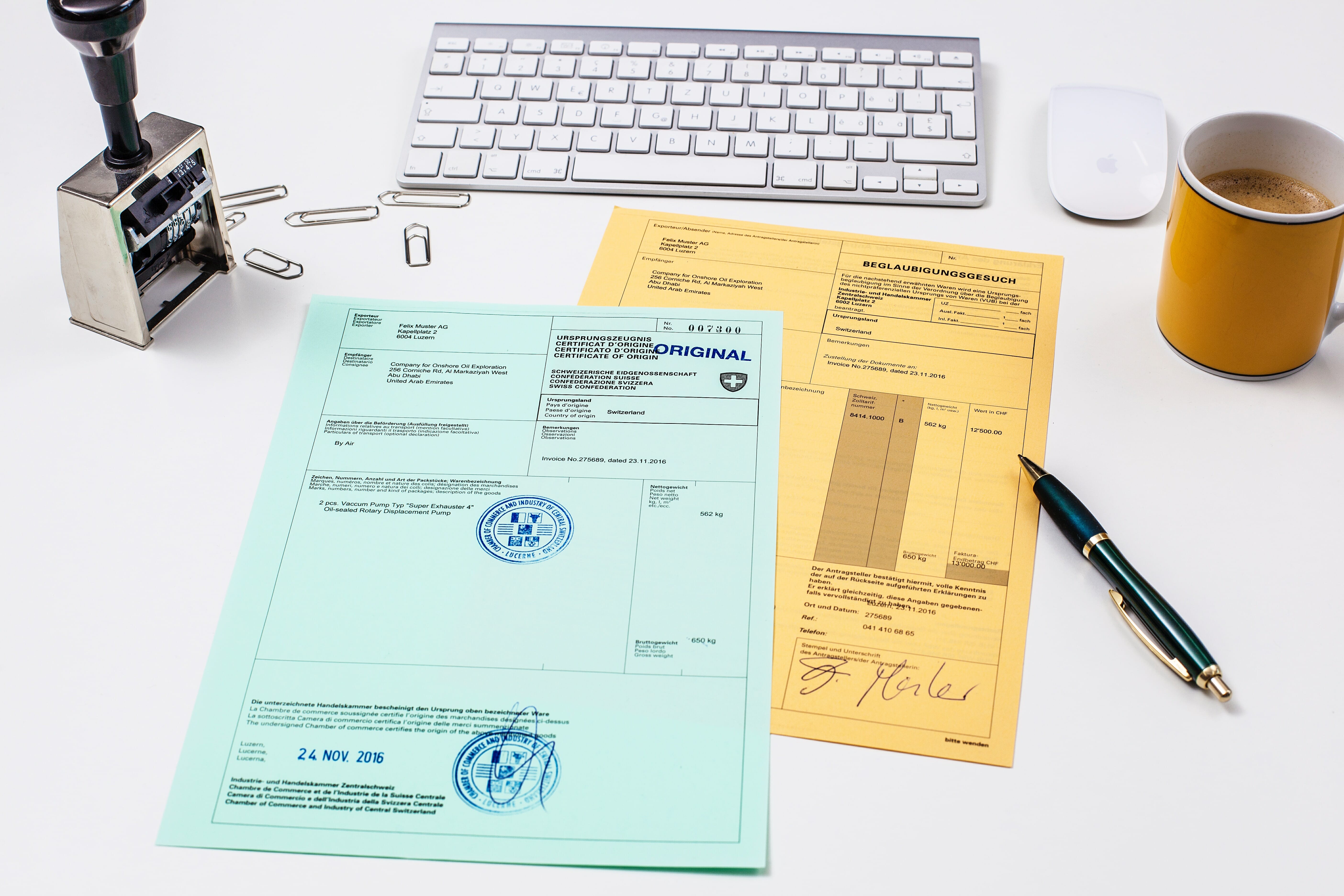 Formulare mit Tastatur, Stift, Kaffeetasse und Stempel drumherum