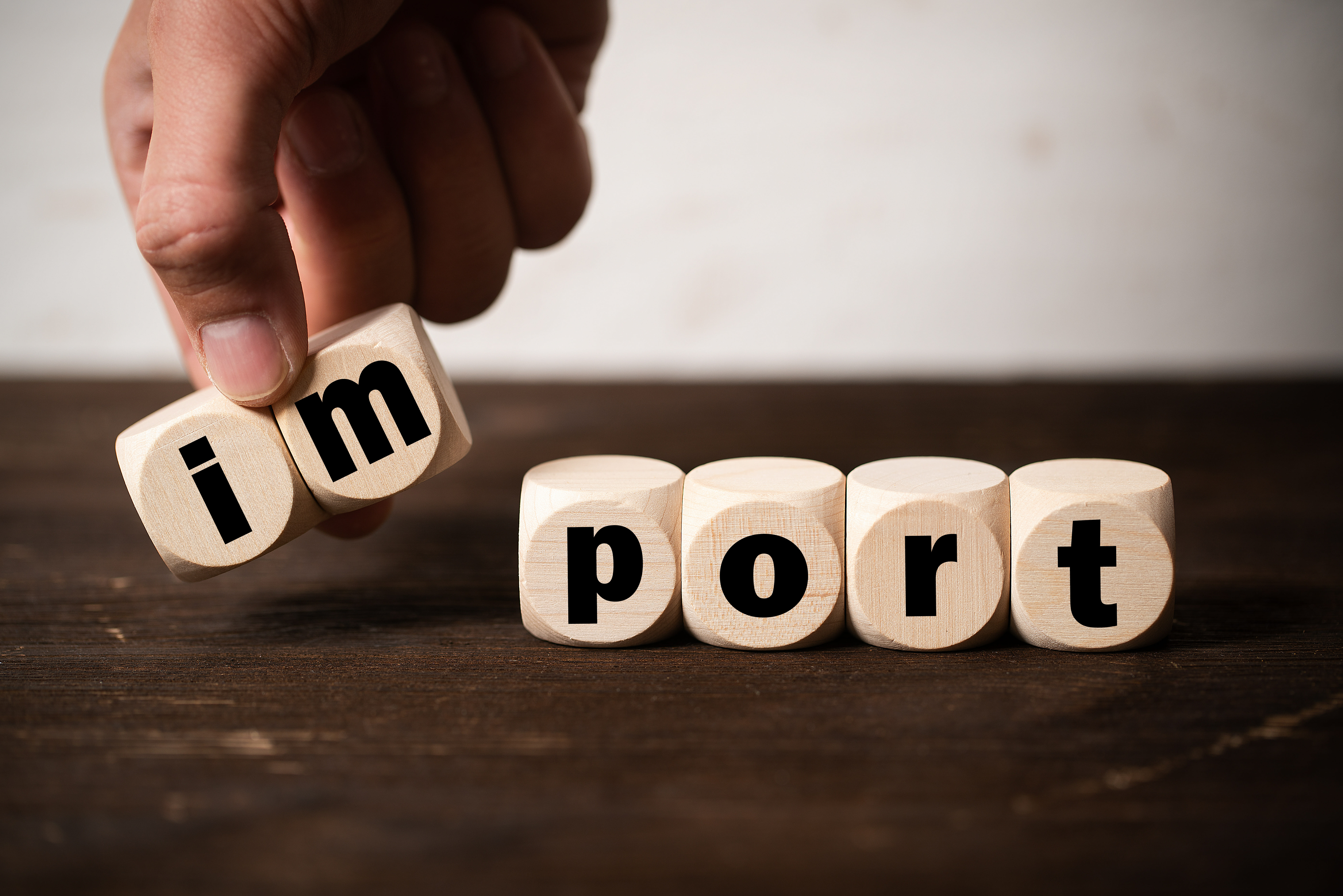 Bild verschiedener Würfel, die aneinander gereiht "Import" ergeben