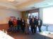 Zufriedene Teilnehmer eines Zollseminars von FineSolutions AG stehen mit Olcay Erden vor einer Pause im Seminarraum vor einem Fenster und einer Wand
