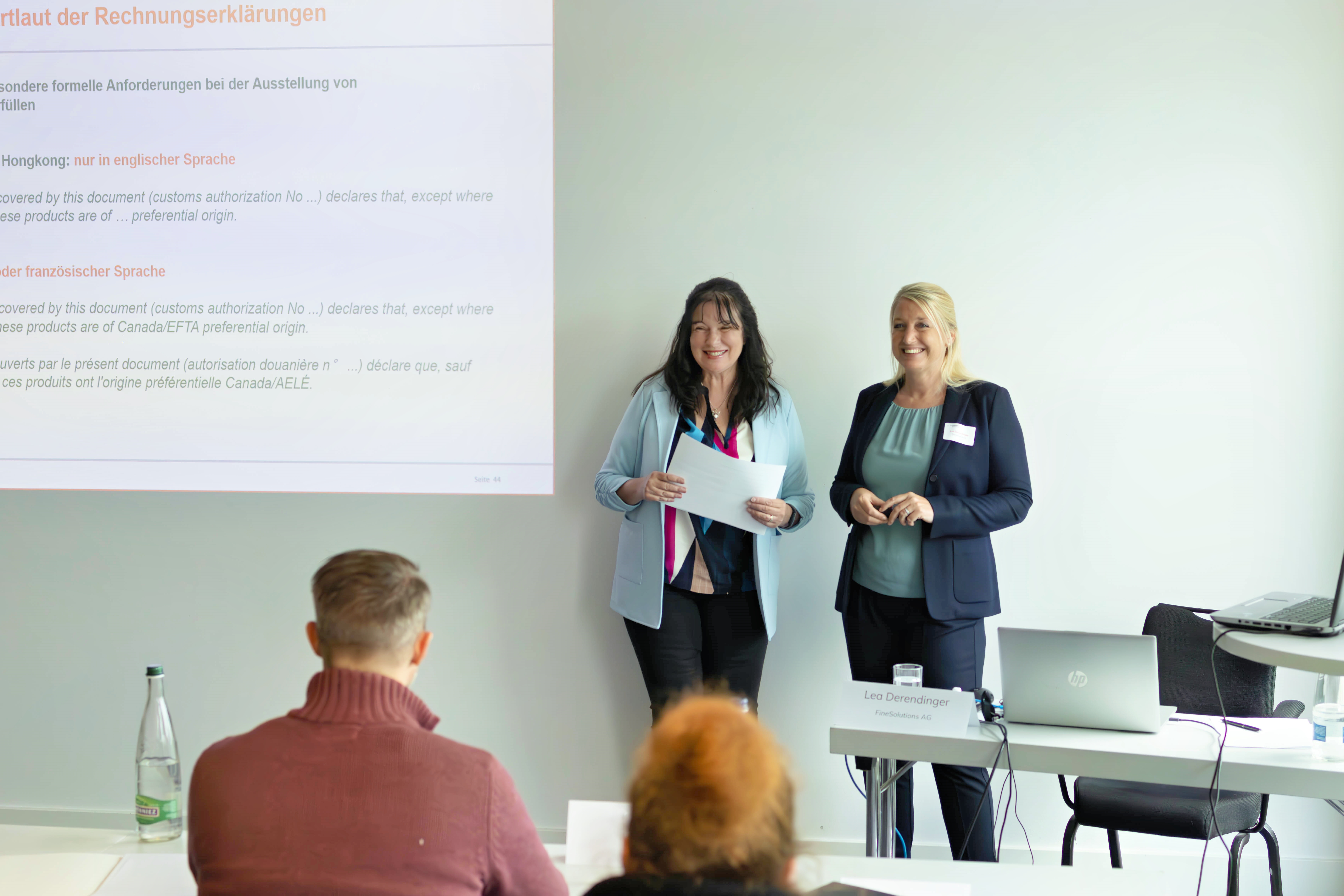 Simone Meierhofer und Lea Derendinger stehen vor den Teilnehmenden eines Zollseminars und beantworten Fragen