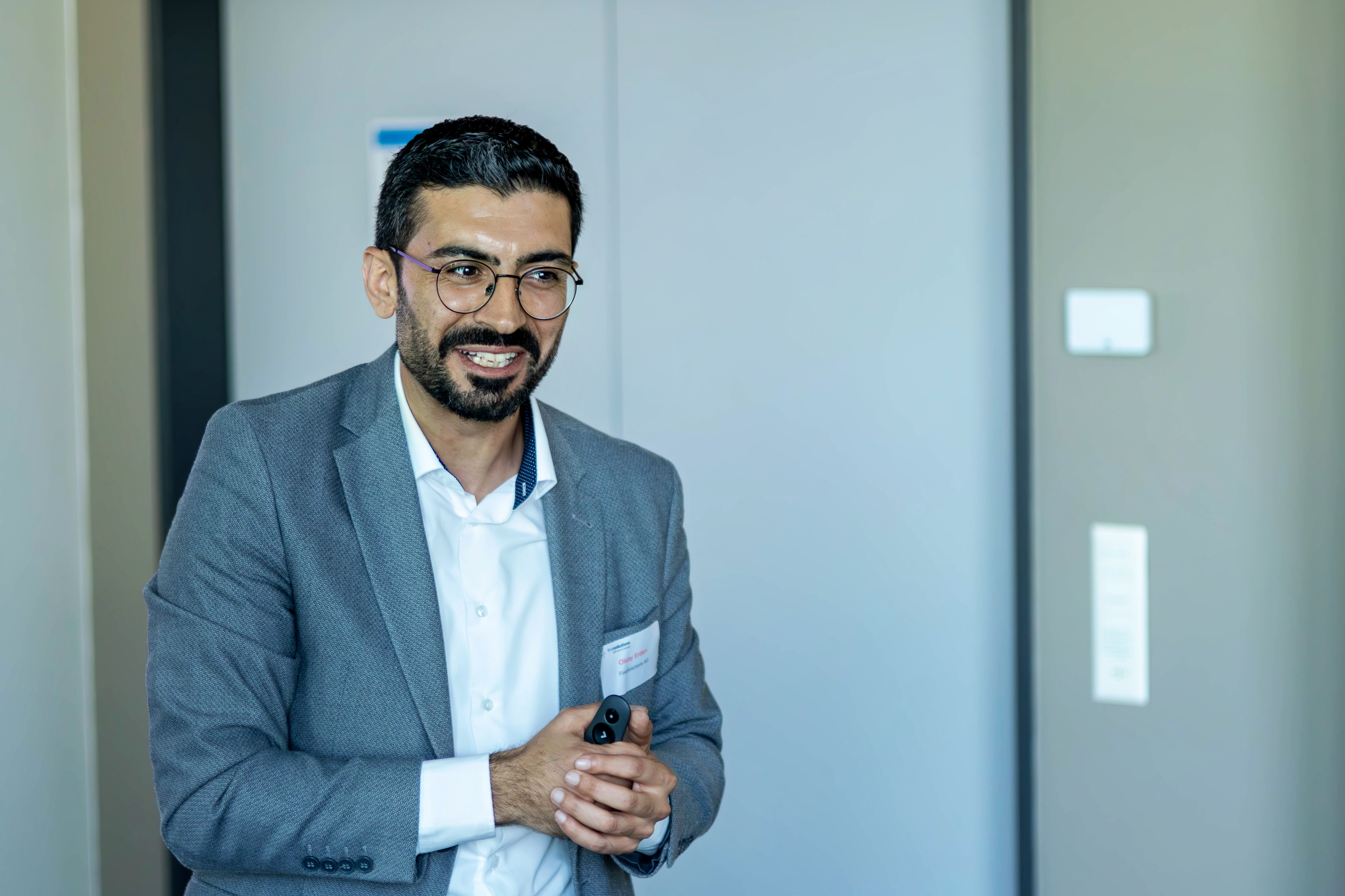 Olcay Erden von FineSolutions steht als Zoll Seminarleiter im Seminarraum vor den Teilnehmenden und hört zu