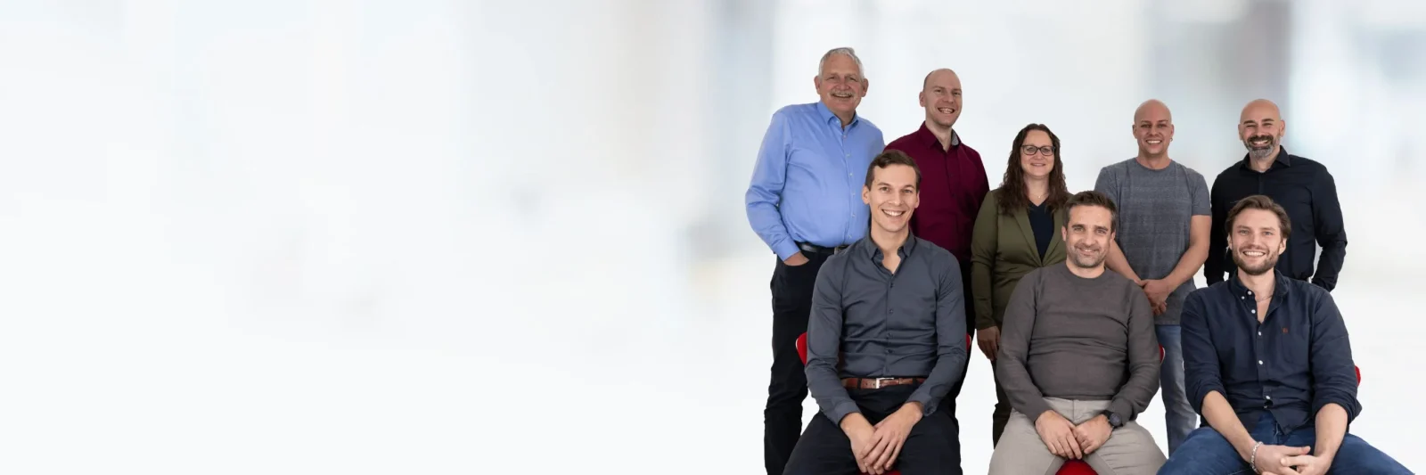 Headerbild mit neutralem Hintergrund, vor dem das Supporteam von finesolutions aufgestellt ist in 2 Reihen mit 5 Personen hinten stehend und 3 Personen voner sitzend